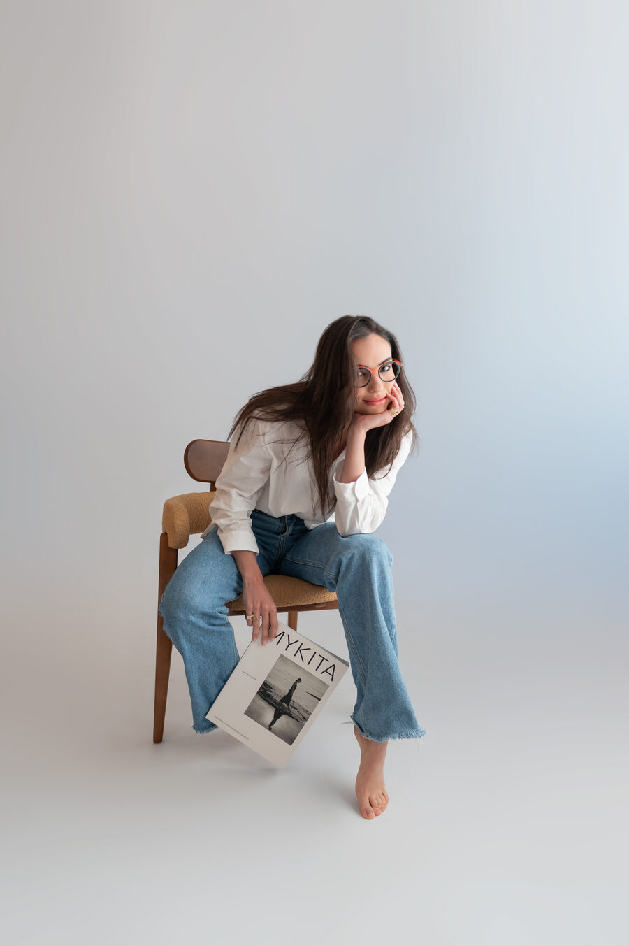 Allyne Flores segurando revista de óculos